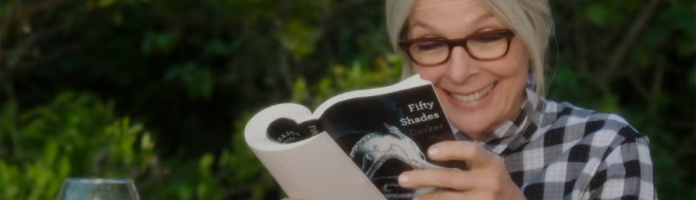 A woman reads Fifty Shades of Grey.