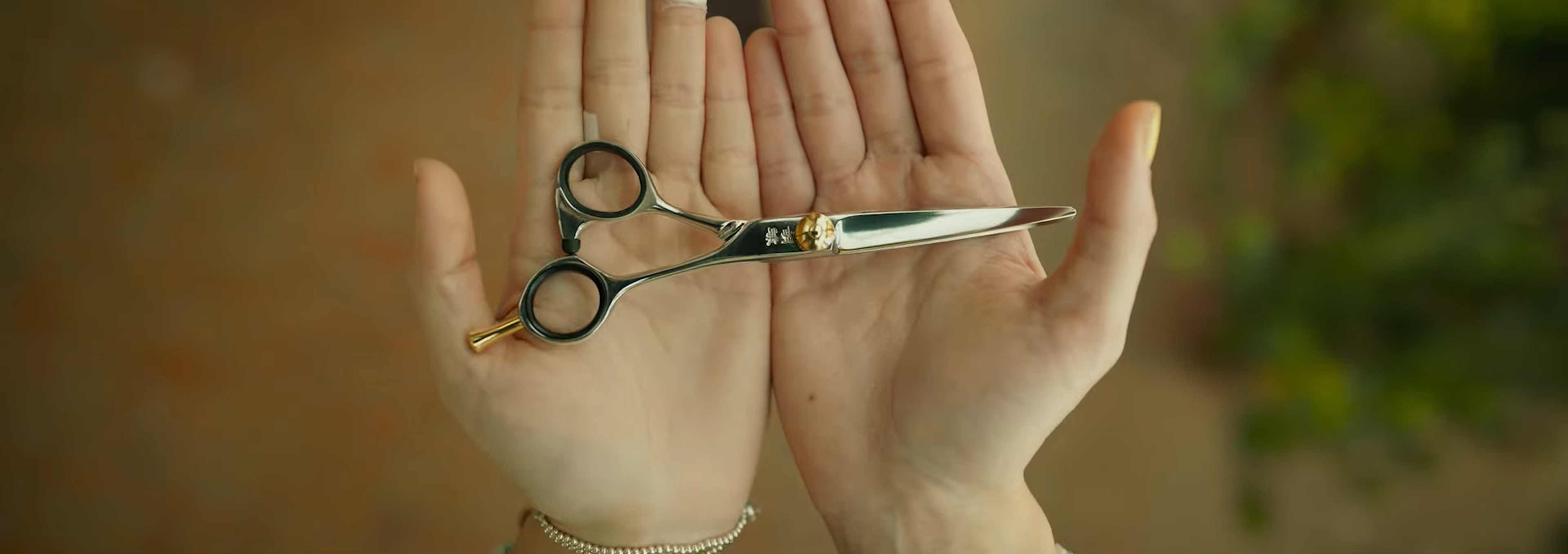 A pair of scissors in someone's hands.